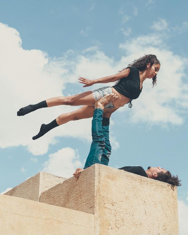 Man performing a controlled strength exercise in a minimalist dark setting.